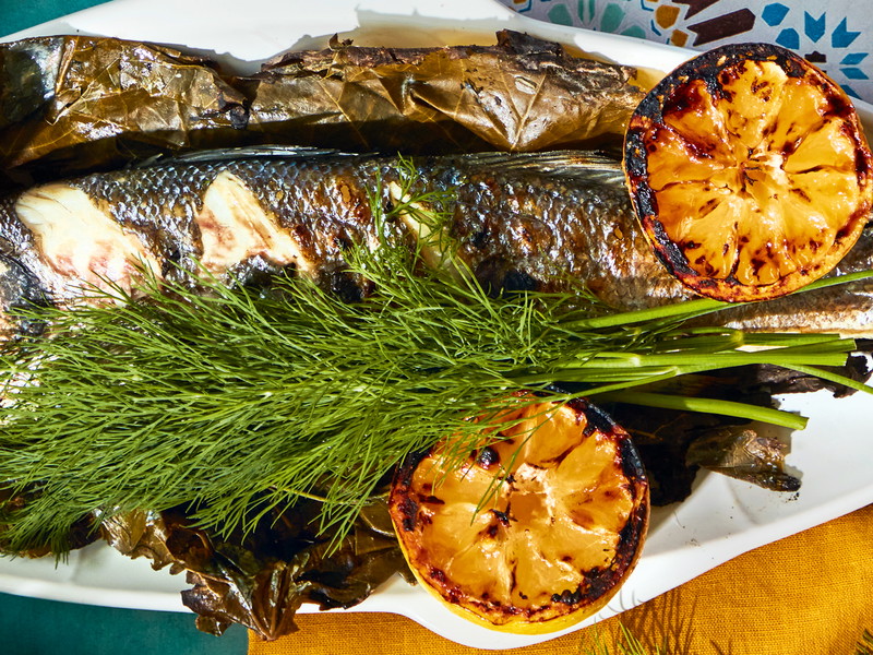 Ganzer Branzino gegrillt in Weinblättern mit Ladolemono-Dressing