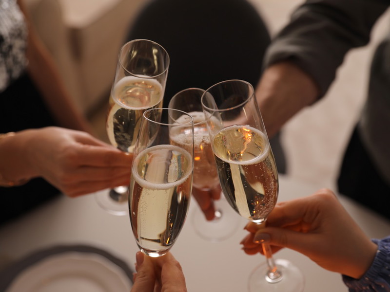 People clinking glasses with champagne at home, closeup