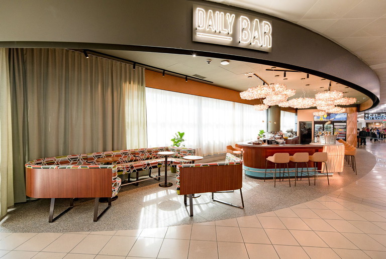 Die Daily Bar bei den C-Gates bietet Passagieren am Flughafen Wien edlen Champagner, erlesene Weine, beliebte Cocktails und Snacks mit Ausblick auf das Flughafen Vorfeld.