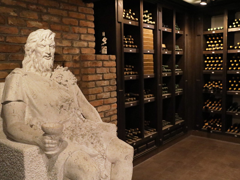 A monumental sandstone sculpture of Bacchus watches over the vinotheque treasures at the Aleksandrovic Winery.