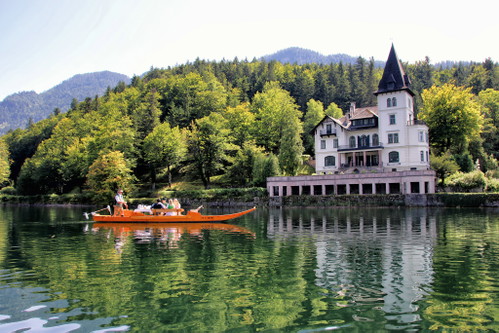 Mit einer traditionellen »Plätte« geht es vorbei an der »Villa Roth« am Grundlsee, möglicherweise zu einer »Lechpartie«. Die kiellosen Schiffe sind das einzig mögliche Anreisefahrzeug, sagt man hier.