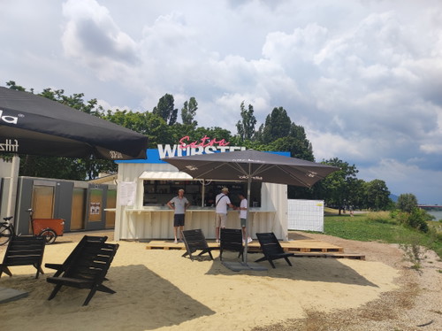 Der Imbiss »Extra Würstel« mit Sandstrand und Ausblick
