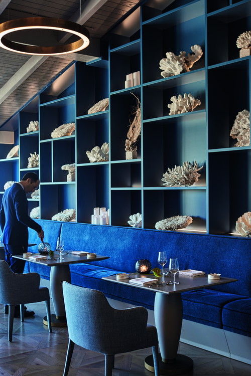 The sea is not only the dominant theme on the plates in the Ocean: a dark blue wall of shelves is decorated with shells and corals.