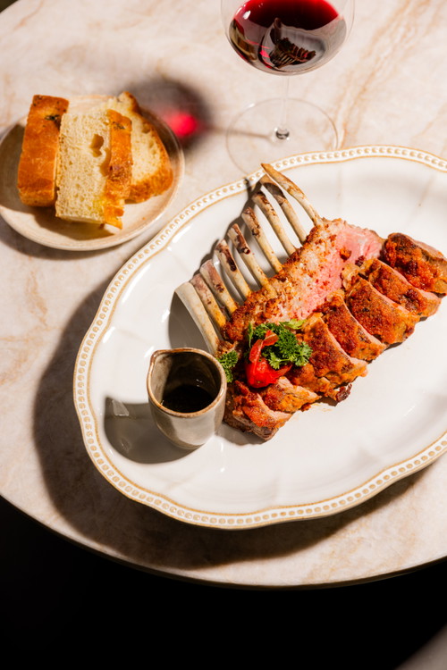 Lammkarree rosa gegart mit Chorizo- und Piemonteser Haselnusskruste, dazu Molho verde Sauce.