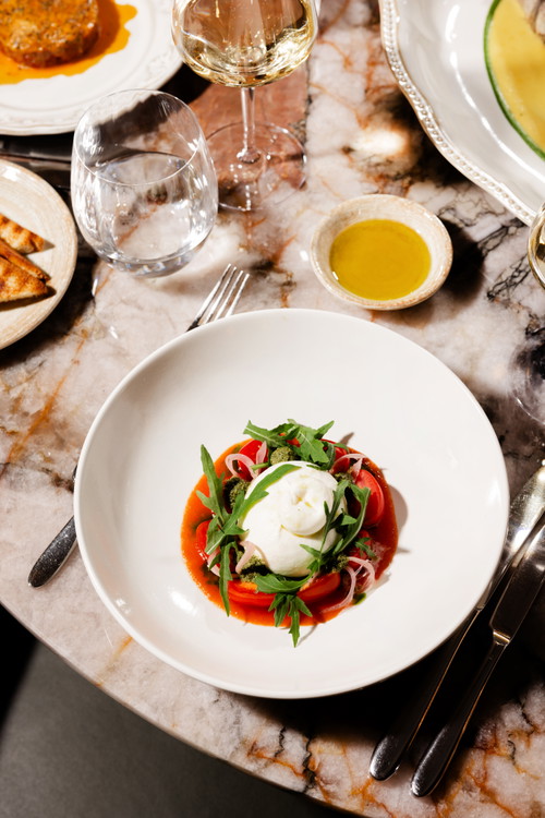 Insalata caprese mit Burrata, Tomaten, Pesto und fermentierter Tropeazwiebel.