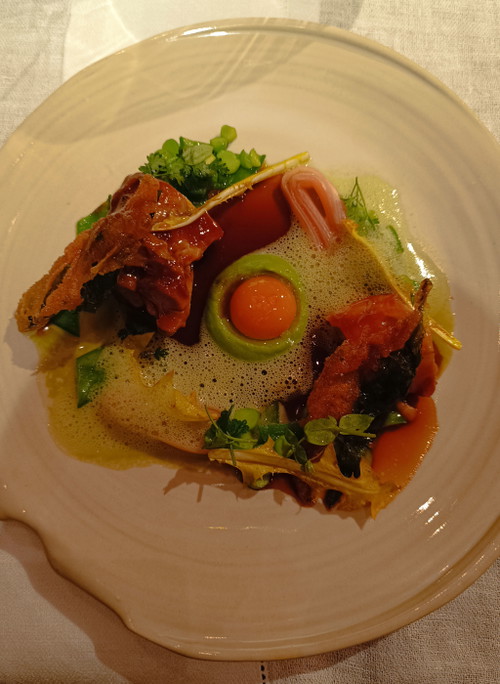 Ziegenkitz Schulter mit jungen Erbsen, in Monarden und Lavendel eingelegter rosa Rhabarber, Bärlauch-Tempura, confierter Wachtelei Dotter und Pimpernelle.