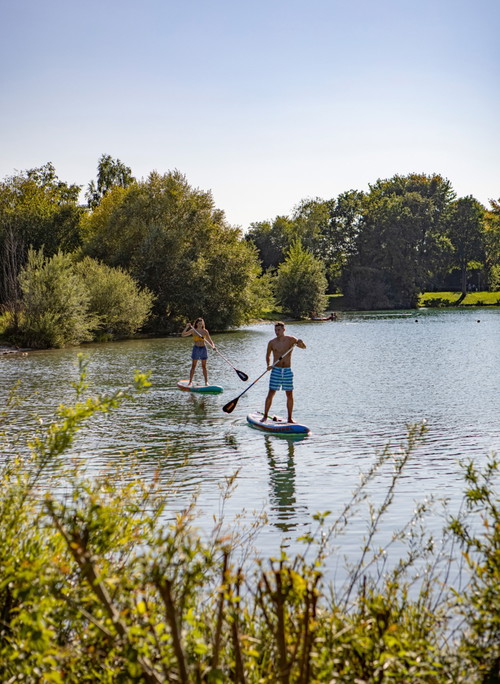 Am Ratzersdorfer See gibt es Freizeitangebote zu Land und zu Wasser – zum Beispiel Stand-up-Paddle-Boote.