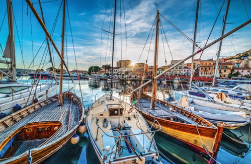 Im Hafen von La Maddalena ankern kleine Segelyachten neben alten Holzbooten. Wunderschön!