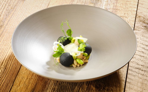 Schwarze Kartoffeln gefüllt mit Quark, Risina-Bohnen, Frühlingszwiebel und Limettenschaum.