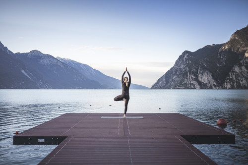 Yoga all'alba in riva al lago