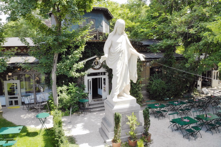 Fast wie in Rio: Eine Christus-Statue heißt die Gäste im Gastgarten des »Concordia Schlössls« willkommen. Unten: der Würstelstand »eh scho wuascht.«.