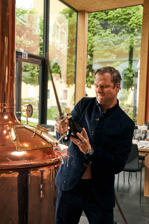 Philipp Hochmair ist auch beim »Köpfen« der Perlage- Flasche mit dem Säbel nahezu perfekt. markus Trinker ist beeindruckt.
