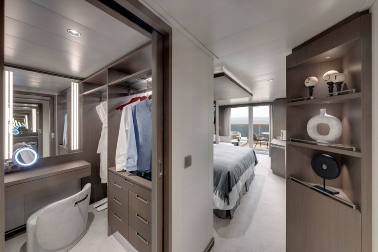 Links der begehbare Kleiderschrank mit Frisierkommode, rechts Blick in den Schlafraum mit privater Terrasse.