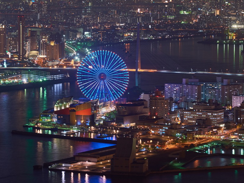 Blick auf Osakas Hafenviertel mit dem leuchtenden Tempozan-Riesenrad. Die pulsierende Metropole zählt zu Japans spannendsten kulinarischen Hotspots.