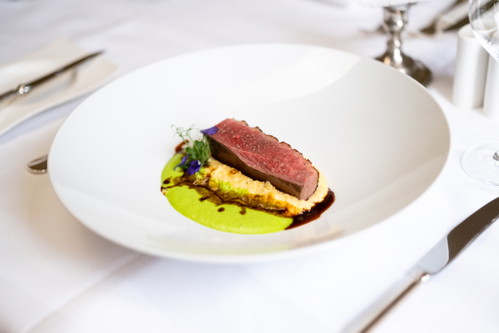 Barbarie Entenbrust auf cremiger Polenta mit Orangenpickel und Erbsen-Espuma.