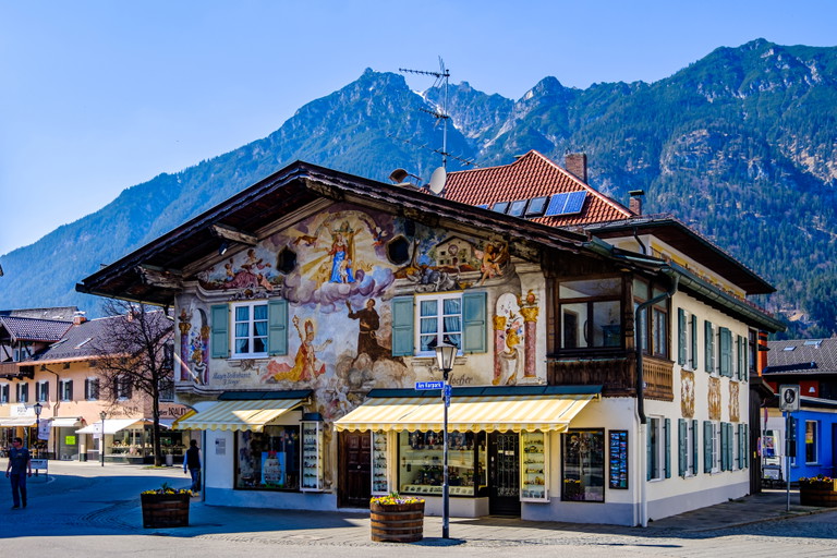 Auf dem Berg das Gipfelkreuz, im Tal die Lüftlmalerei. Garmisch-Partenkirchen vereint Naturerlebnis und Handwerkskunst.