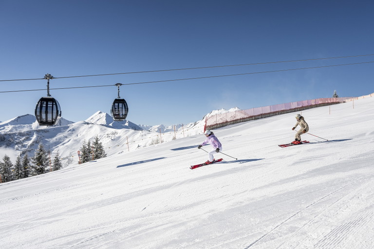 Skifahren unterhalb der Gondeln der Kieserlbahn im Skigebiet Großarltal-Dorfgastein