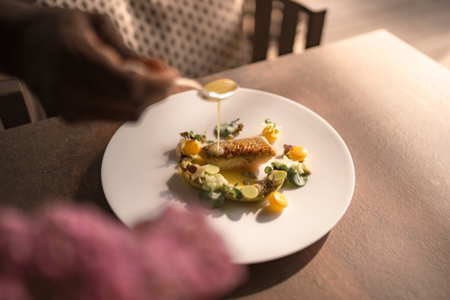 Trota marinata, cetriolini in conserva e salsa alle erbe: un equilibrio tra freschezza e note aromatiche.