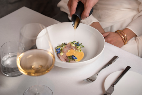 Trota marinata, cetriolini in conserva e salsa alle erbe: un equilibrio tra freschezza e note aromatiche.