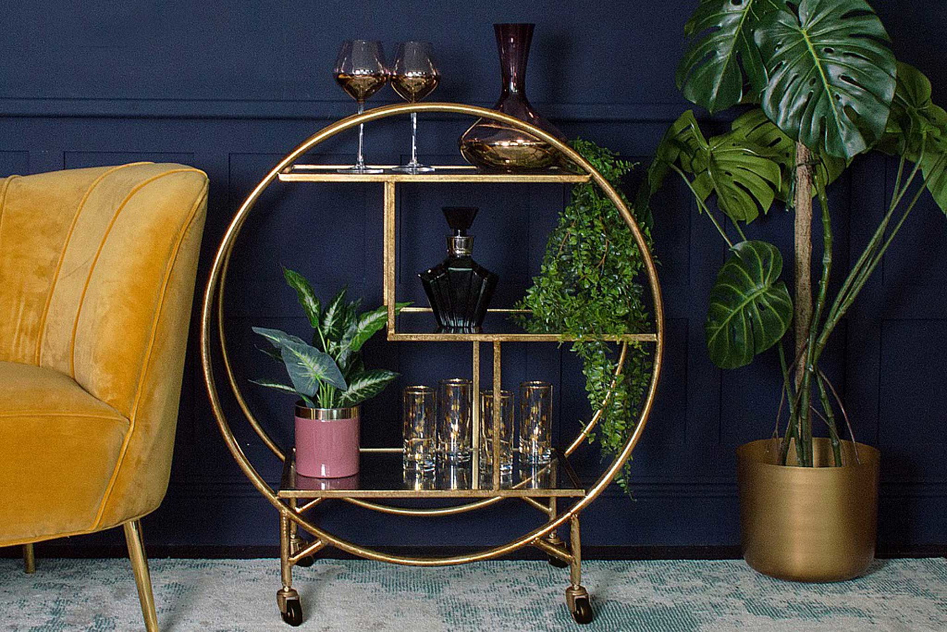 Der filigrane Barwagen mit drei gläsernen Oberflächen und goldenem Finish sorgt für Hollywood-Glamour. audenza.com