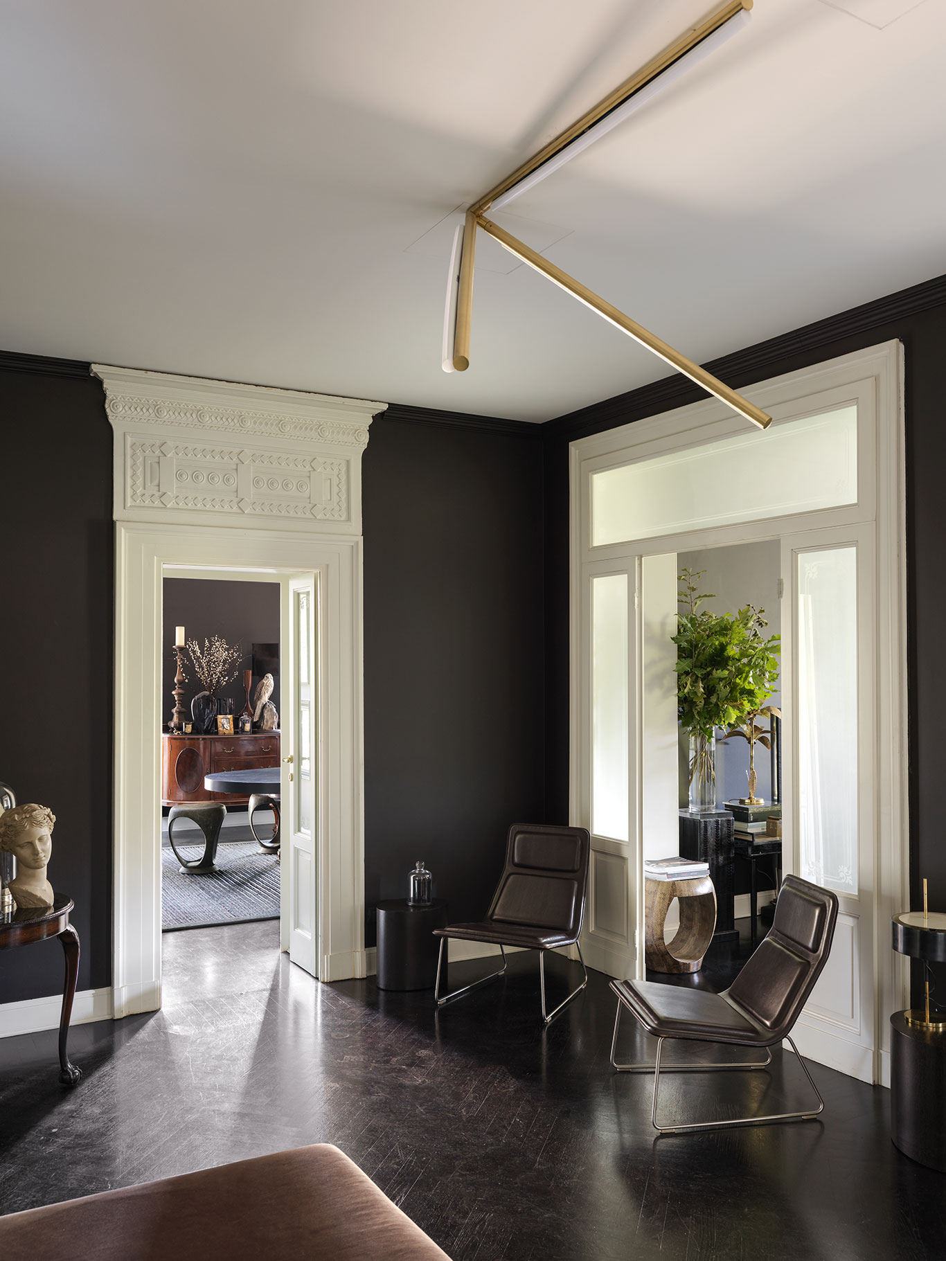 Architektonische Details der Wohnung wie die geometrisch verzierten Türgiebel gefielen Neil sofort. Im Vorzimmer sitzt man auf »Low Pad«-Stühlen von Jasper Morrison für Cappellini.