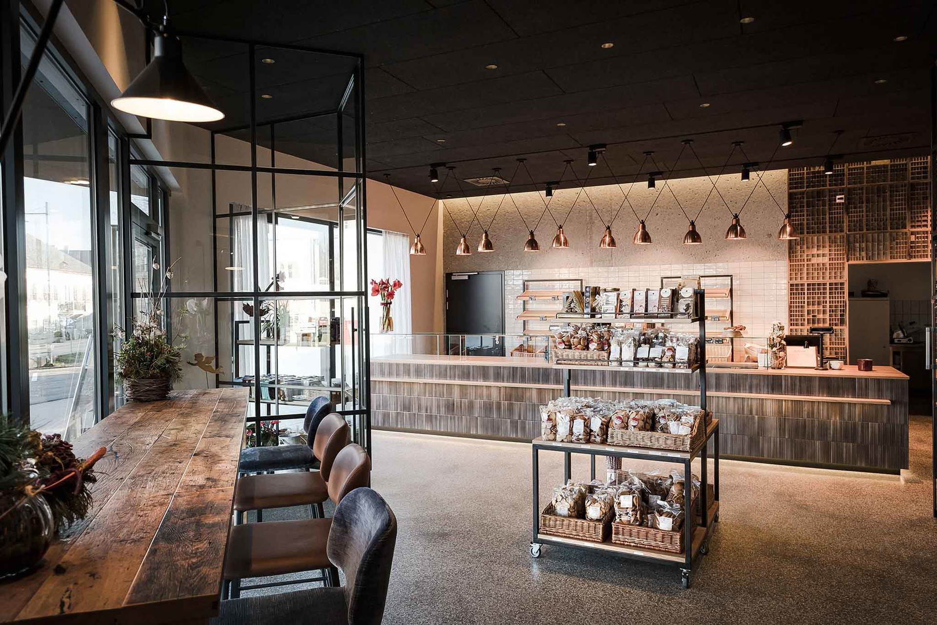 Altholz aus Eiche, geschliffener Beton und offenes Leder: Die Natürlichkeit des Urprodukts Brot spiegelt sich auch in der Architektur dieser Bäckerei im Traunviertel wider. Ein stimmiges Gesamt-Ensemble. baumgartner-baeckerei.at