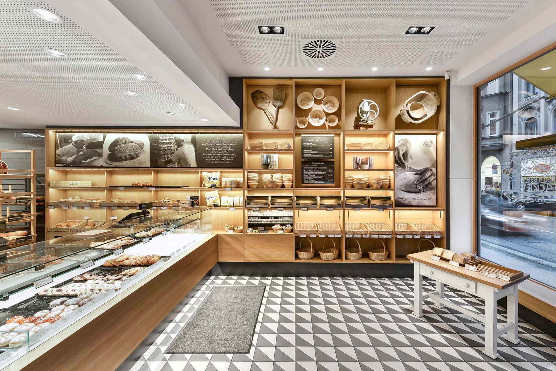 Der Tiroler Qualitätsbäcker war einer der Ersten, der&nbsp;auf feine Optik zum reschen Brot setzte. Durchgängiges Element ist die Glas-Holz-Architektur sowie das schwarz-weiße Fliesendesign. ruetz.at