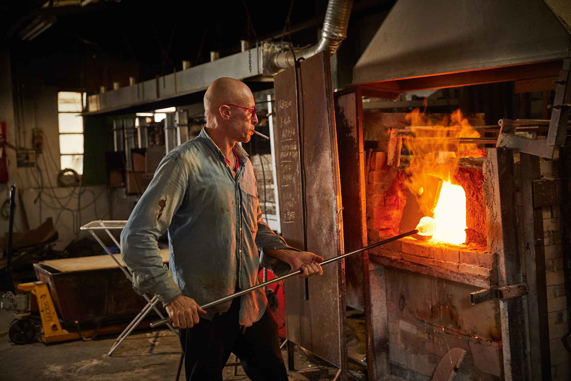 Das Glasstück wird an langen Metallstücken in den Brennöfen bis zu über 1000 Grad Celsius erhitzt&nbsp;und mit Werkzeugen geformt.
