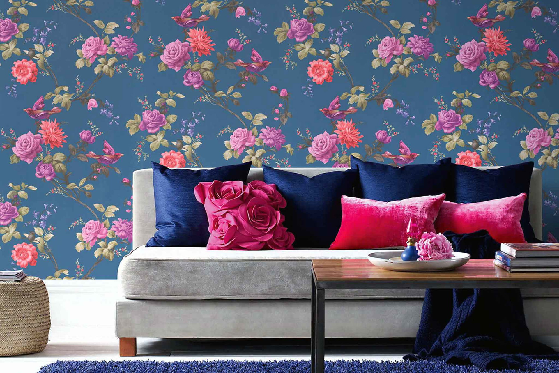 Wie ein exklusiver Indoor-Rosengarten inszeniert sich die Tapete »Oriental Blue« mit Vogel-Motiv und voll erblühter Flora. Statement-Wand. grahambrown.com