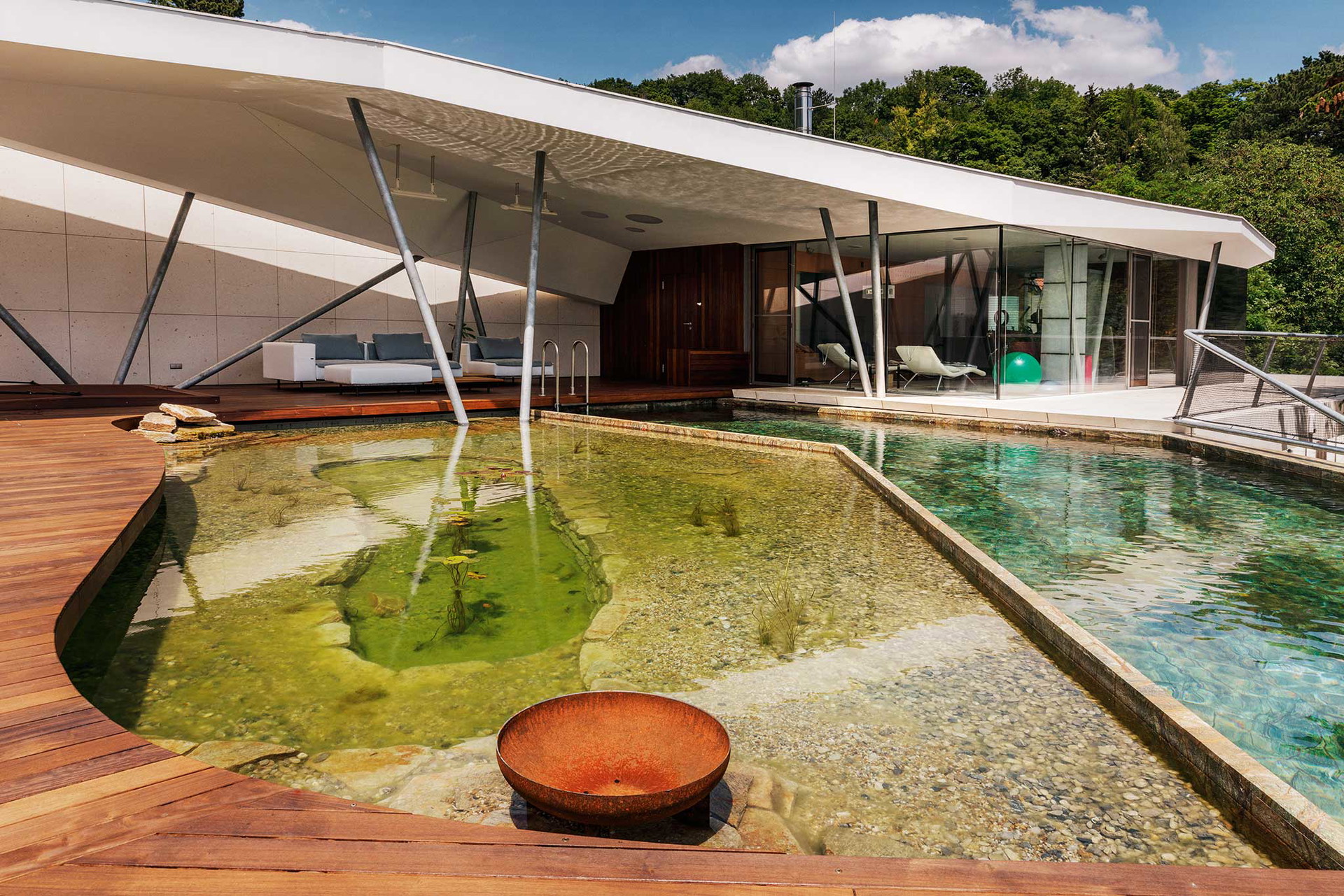 Naturpool und Zierteich treffen auf Möbel von Extremis, Paola Lenti und Viteo. Stein: »Rainforest« von Breitwieser. kramerundkramer.at