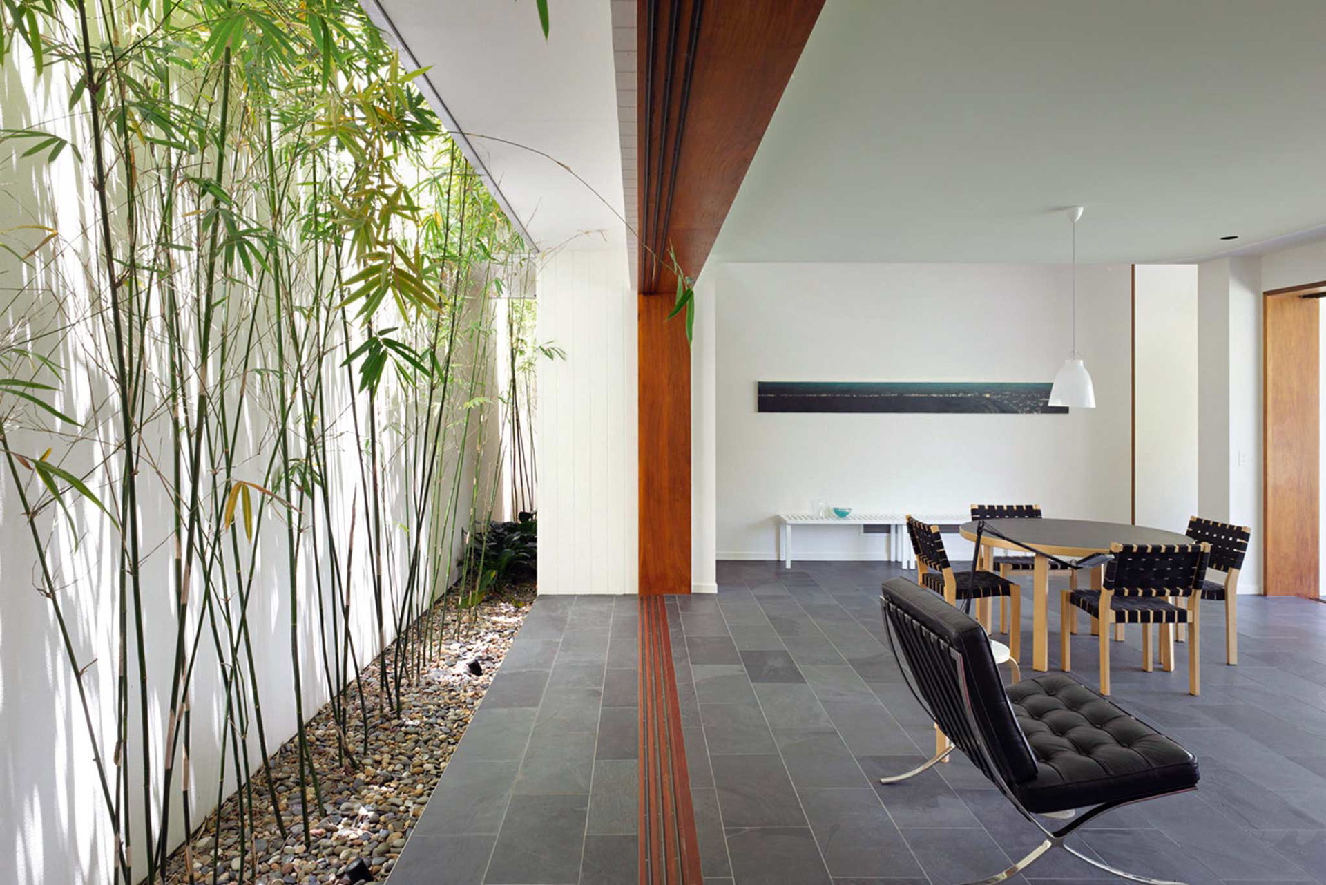 Der australische Architekt Shane Plazibat hat schon Wohnhäuser in London, Hongkong und Down Under geplant. Das Fig Tree Pocket House am Stadtrand von Brisbane blickt auf der einen Seite in einen großen Feigengarten, während auf der anderen Seite ein schmales Bambusatrium vor die Wohnzimmerrückwand eingeschnitten ist.&nbsp;plazibat.com.au