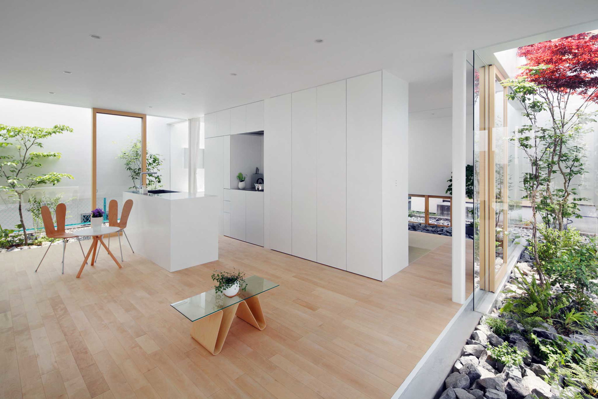 Die japanischen mA-Style Architects bauten in Fujieda ein Haus, das sie mit einem schmalen Streifen aus Licht und Grün umsäumten. Die umlaufende weiße Mauer schützt nicht nur vor neugierigen Blicken, sondern reflektiert auch das Sonnenlicht und leitet es auf diese Weise in den Innenraum.&nbsp;ma-style.jp