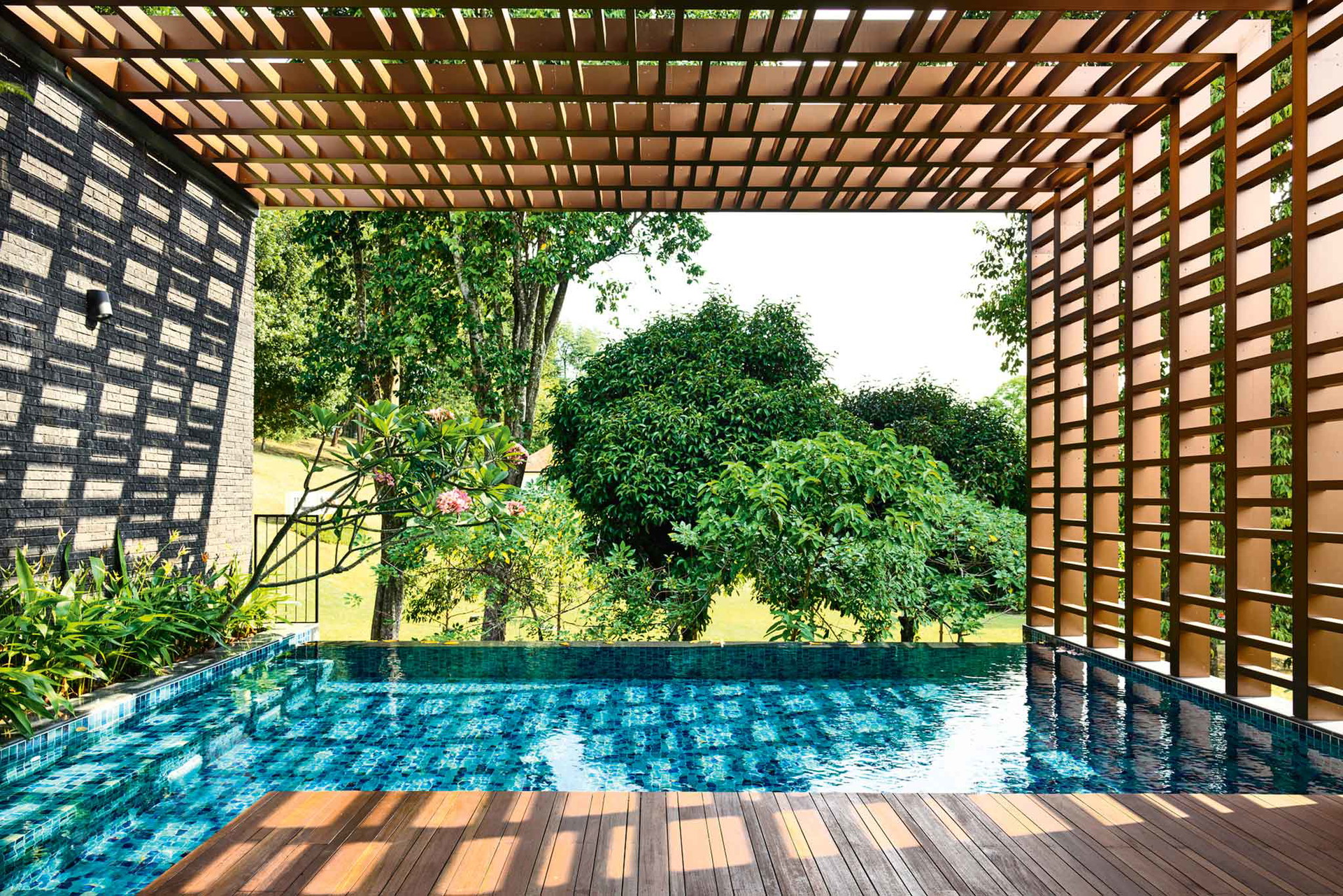 Beim Viewing Back House in Singapur kommt man direkt vom Wohnzimmer über die überdachte Terrasse in den Pool. Die Lichtreflexionen sind im Konzept inbegriffen.&nbsp;hyla.com.sg