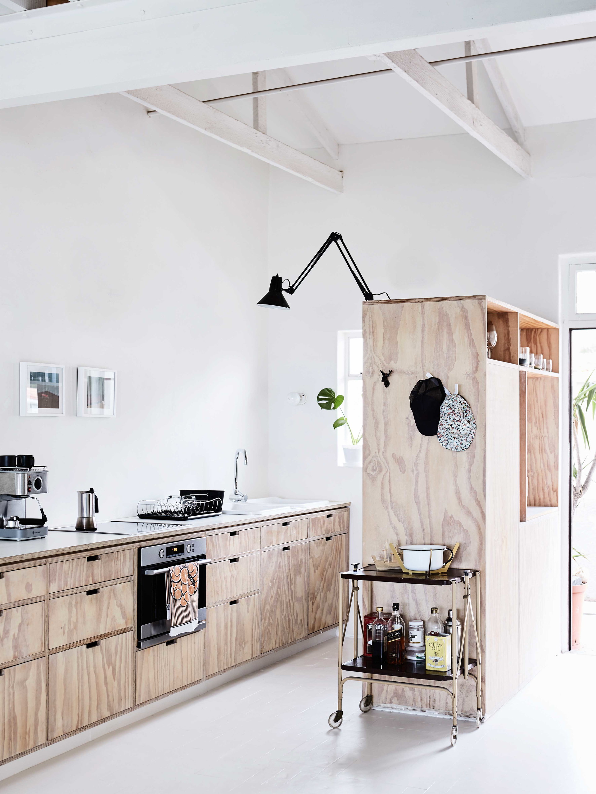 Pine fresh: Die geschliffene, organisch anmutende Seidenkiefer gibt dem Material einen neuen, guten Ruf. Ihre urbane Ästhetik und die cleanen skandinavischen Vibes machen sie zum Material du jour für Architekt Michael Lumby. Seidenkiefer ist haltbar, vielfältig, nachhaltig und leistbar. In diesem Beispiel dient eine frei stehende Einheit der Trennung von Koch- und Freizeitbereich. Zusätzliches Arbeitslicht spendet eine Knickgelenklampe im Industrial Style à la Angelpoise.