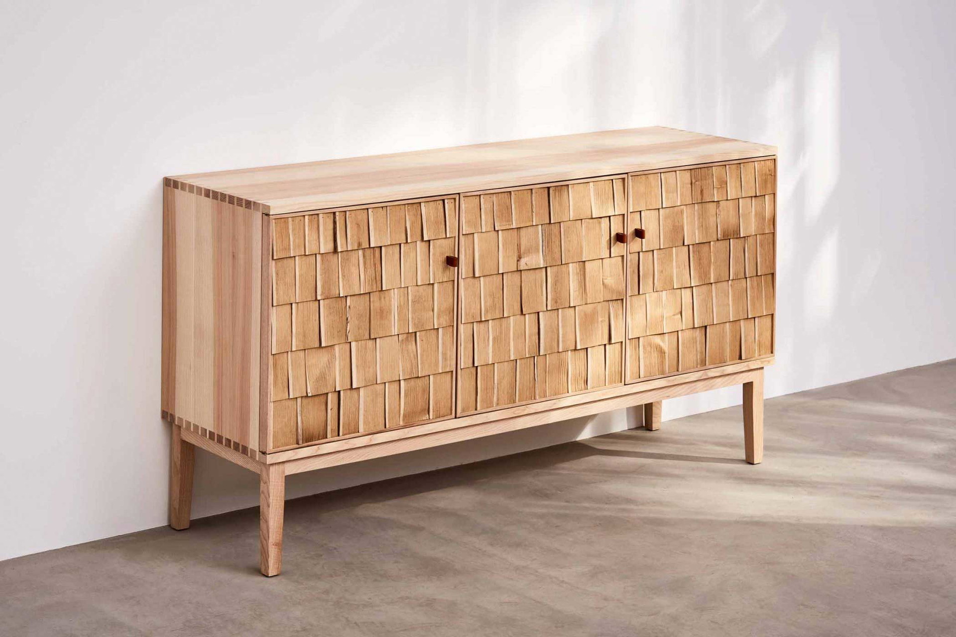 Au naturel: Die dreidimensionale Haptik und die Kombination aus Esche und Kastanie machen das Sideboard »Shake« so reizvoll. Die Vertäfelung der Türen ist hauchdünn und somit sehr leicht. benchmarkfurniture.com