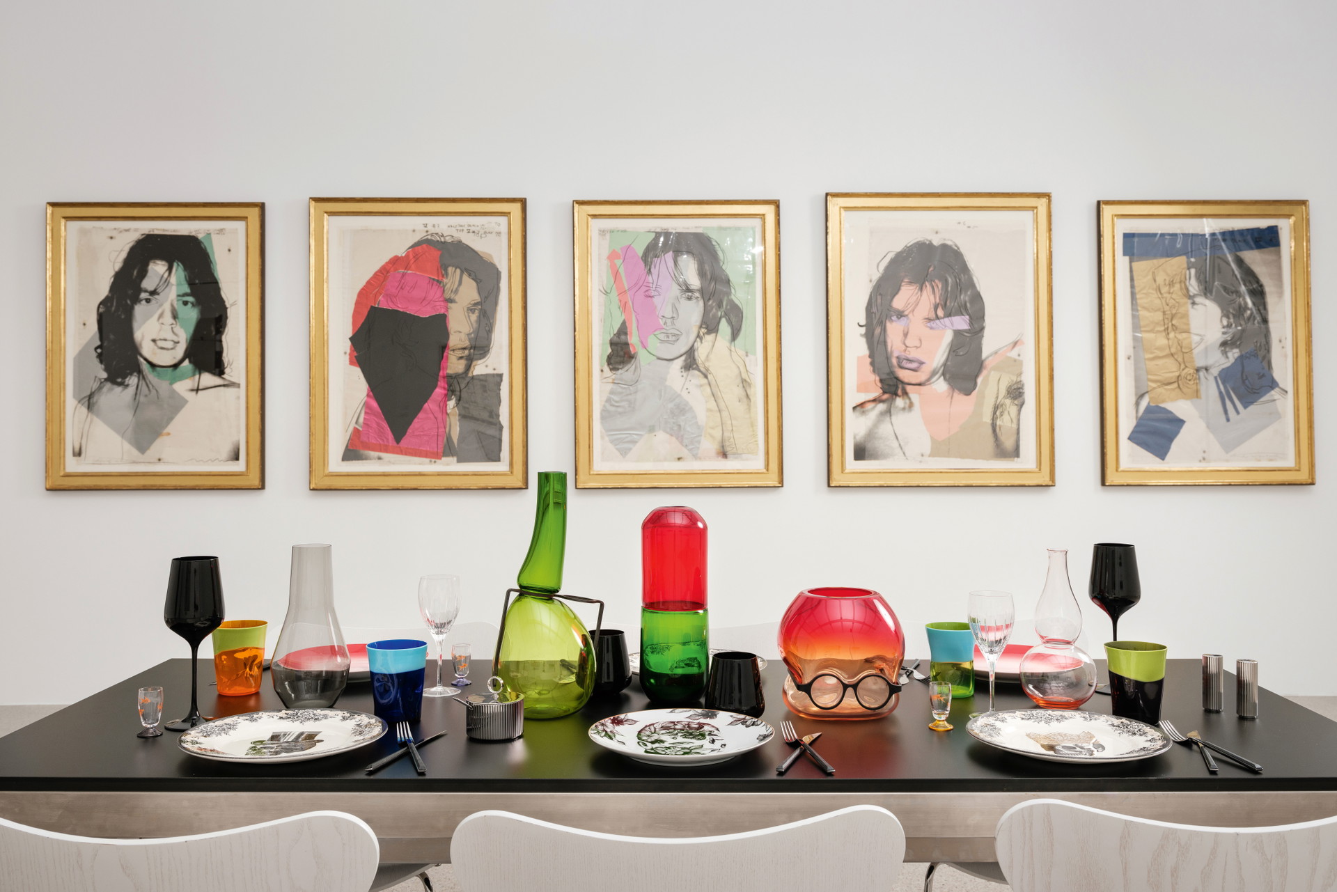Andy Warhol »Mick Jagger«, 1975. (Kunstwerke: © The Andy Warhol Foundation for the Visual Arts, New York/Bildrecht Wien; mumok – Museum moderner Kunst Stiftung Ludwig Wien, Leihgabe der Sammlung Ludwig, Aachen seit 1981) Tableware:&nbsp;Schwarze Wein- und Wassergläser und Besteck, beides von Zara Home. zarahome.com; Teller mit Totenkopf-Design von Homelab, Teller mit Gesicht »Cilla Marea« von Rosenthal, Zuckerdose und Salz- und Pfefferstreuer von Georg Jensen, Weingläser »Iriana« von Christofle - Alles bei Cuisinarum. cuisinarum.at; Schnapsgläser mit Goldfischen von Stillsegler. stillsegler.com; Bunte Wassergläser »Dandy« von NasonMoretti via Ma Maison. ma-maison.at; Grüne und rote Vase »Where are my Glasses?« und »Happy Pills« von Venini, Rosalin-Vase. Alles von Lobmeyr. lobmeyr.at; Zweifärbige rot-rosa Teller »BeColour« von Rosenthal. rosenthal.de