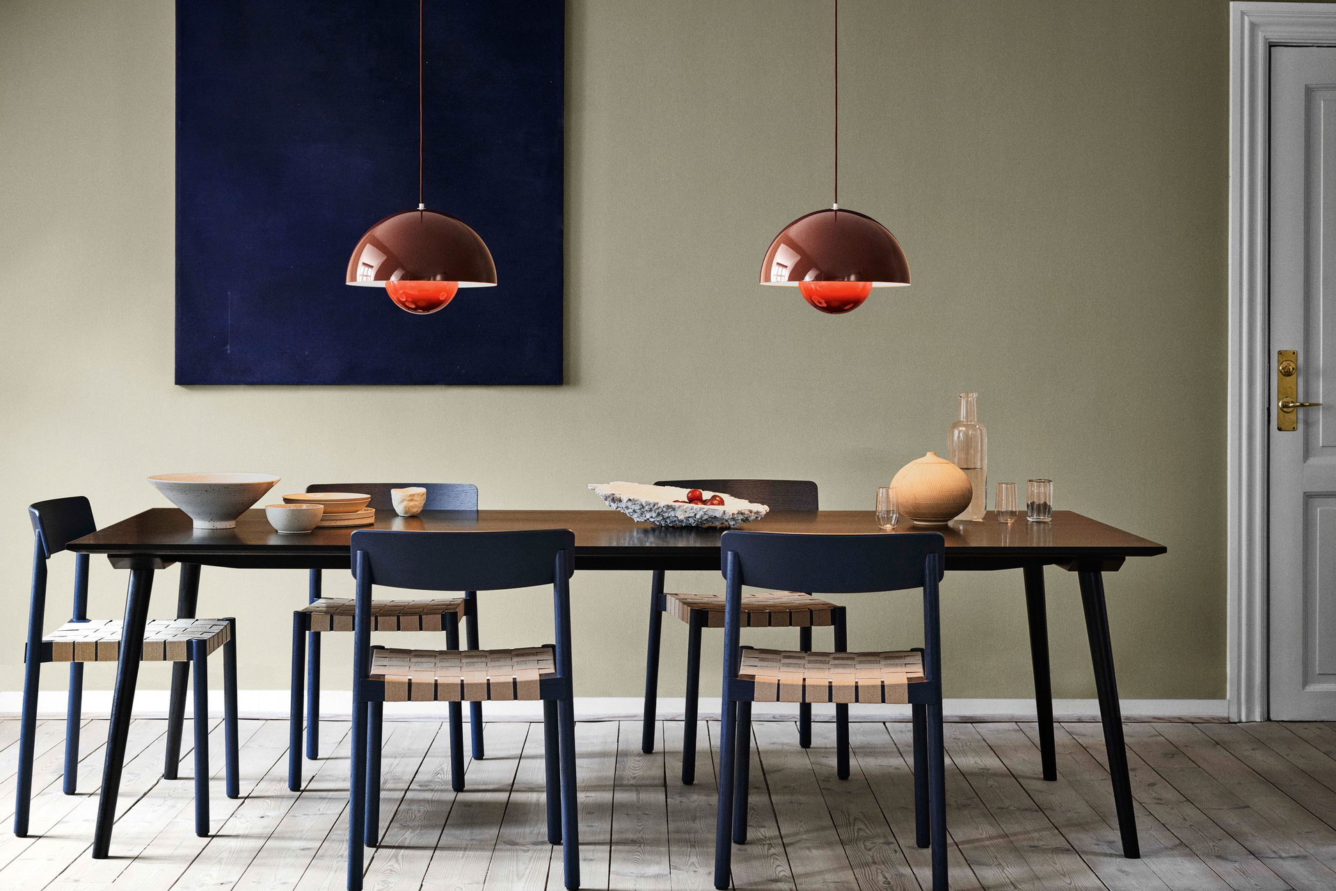 Minimal Effort: Der Diningchair »Betty TK1« von &amp;tradition steht für skandinavische Leichtigkeit und bekommt durch den dunkelblauen Anstrich mehr Finesse. Außerdem überlässt er den roten Leuchten namens -»Flowerpot« das Rampenlicht. Interessantes Einrichtungsdetail: Das Kunstwerk im Hintergrund ist nicht zentral zum Tisch ausgerichtet und bringt dadurch Dynamik in die Raumkomposition.&nbsp;andtradition.com