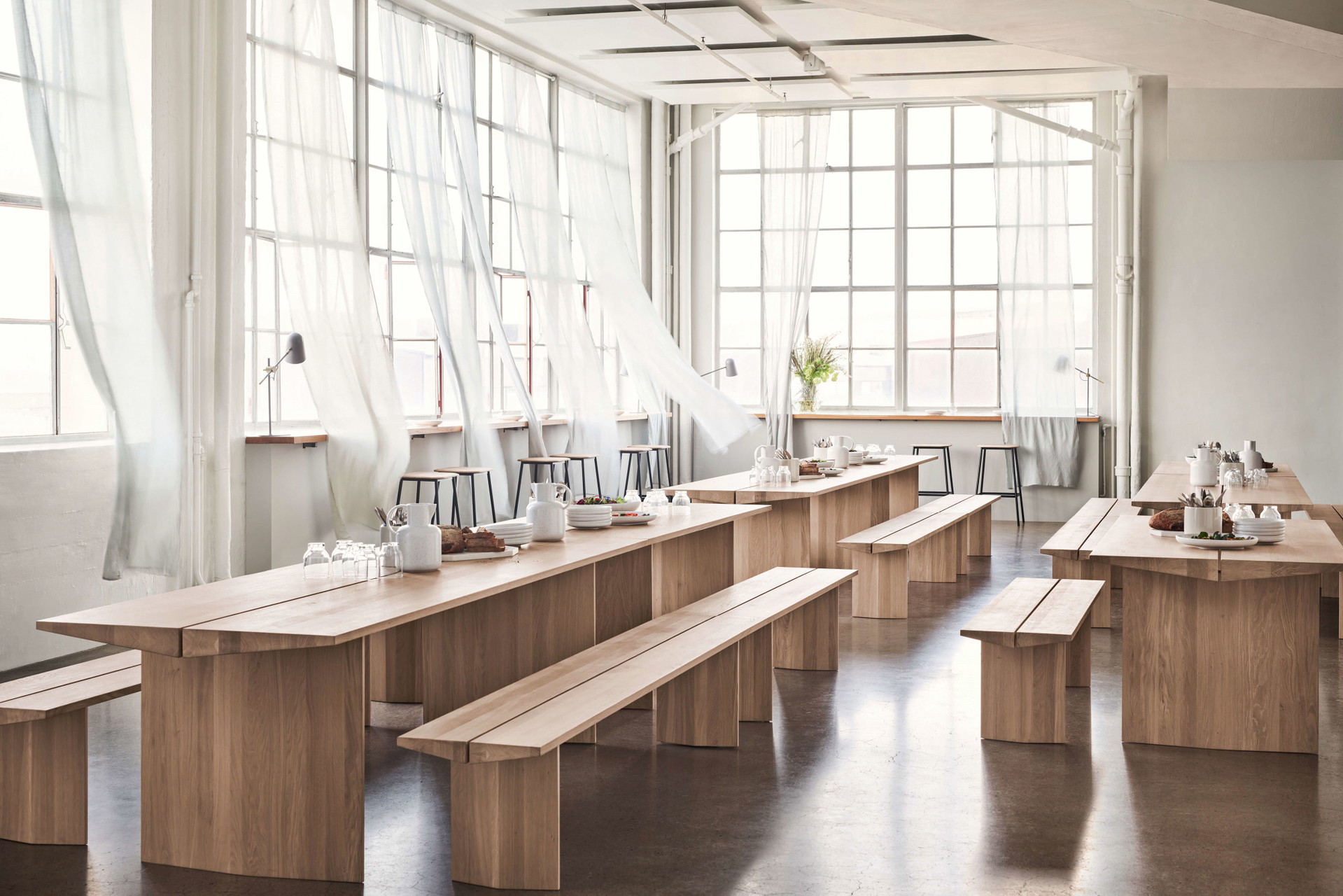 Neu gedacht: Auch wenn es sich hier nicht um ein klassisches Esszimmer, sondern mehr um eine Kantine handelt: Ist die einheitliche Gestaltung von geölter Eiche mit cremefarbenem Geschirr nicht reizvoll? Hier wird generell mit wenig Kontrast gearbeitet. Nur die Stuhlbeine der Barhocker sind aus schwarzem Metall und brechen die Symbiose von Keramik und Holz. Das sorgt für optische Erfrischung. bolia.com