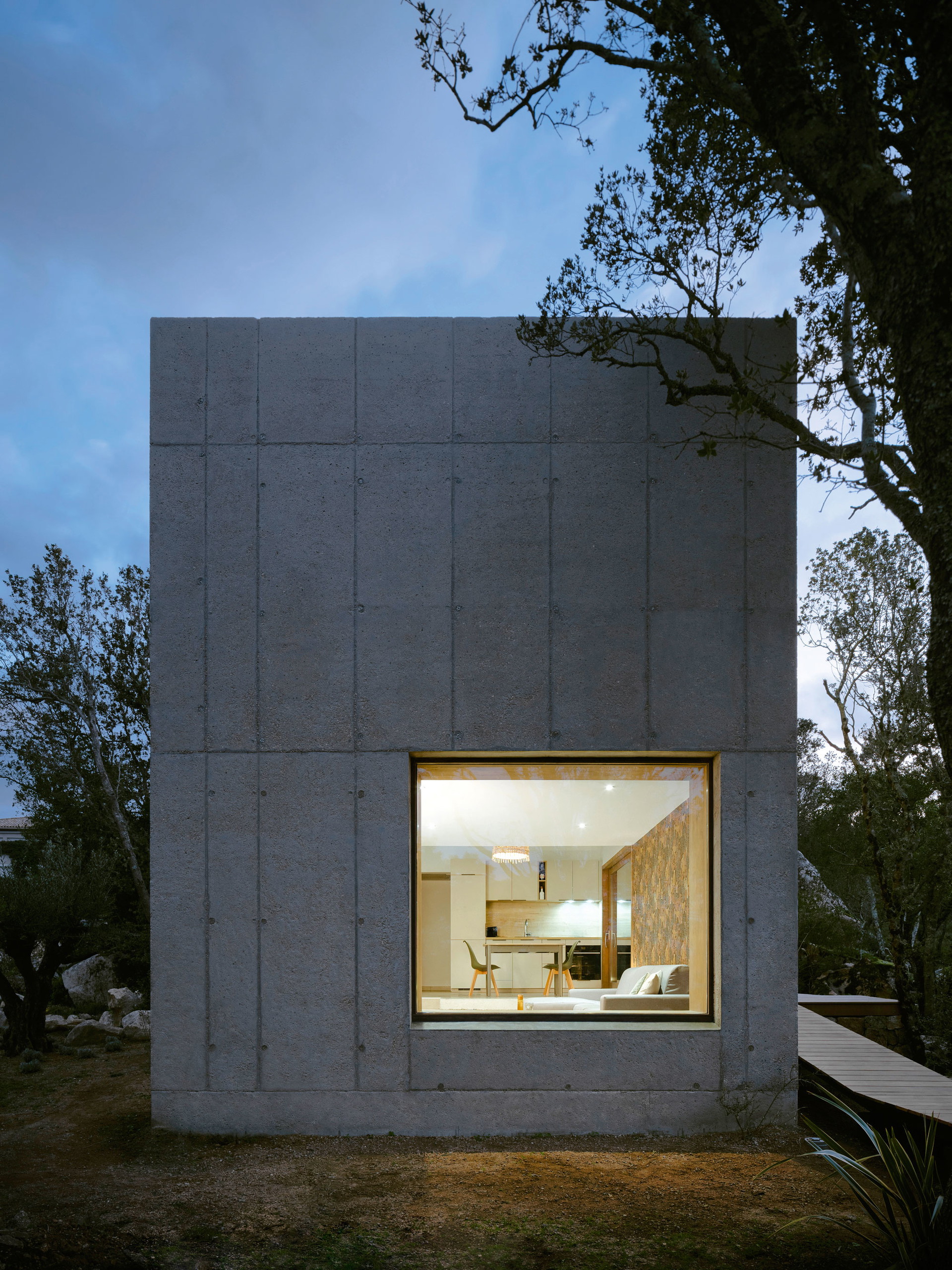 Betonhaus Casa R, Korsika: Auf einem felsigen Hanggrundstück in der Gemeinde Sotta baute das französische Büro Orma Architettura diese schlichte Wohn­- kiste für einen Künstler – auf einer Grundfläche von gerade einmal 49 Quadratmetern. Der grobe Sichtbeton versteht sich als Zitat auf den felsigen Untergrund. In den Innenräumen hingegen dominieren warme, haptisch angenehme Materialien. Unterschiedliche Raum­höhen sorgen für raffinierte, ineinander verschränkte Wohnbereiche. orma-architettura.com