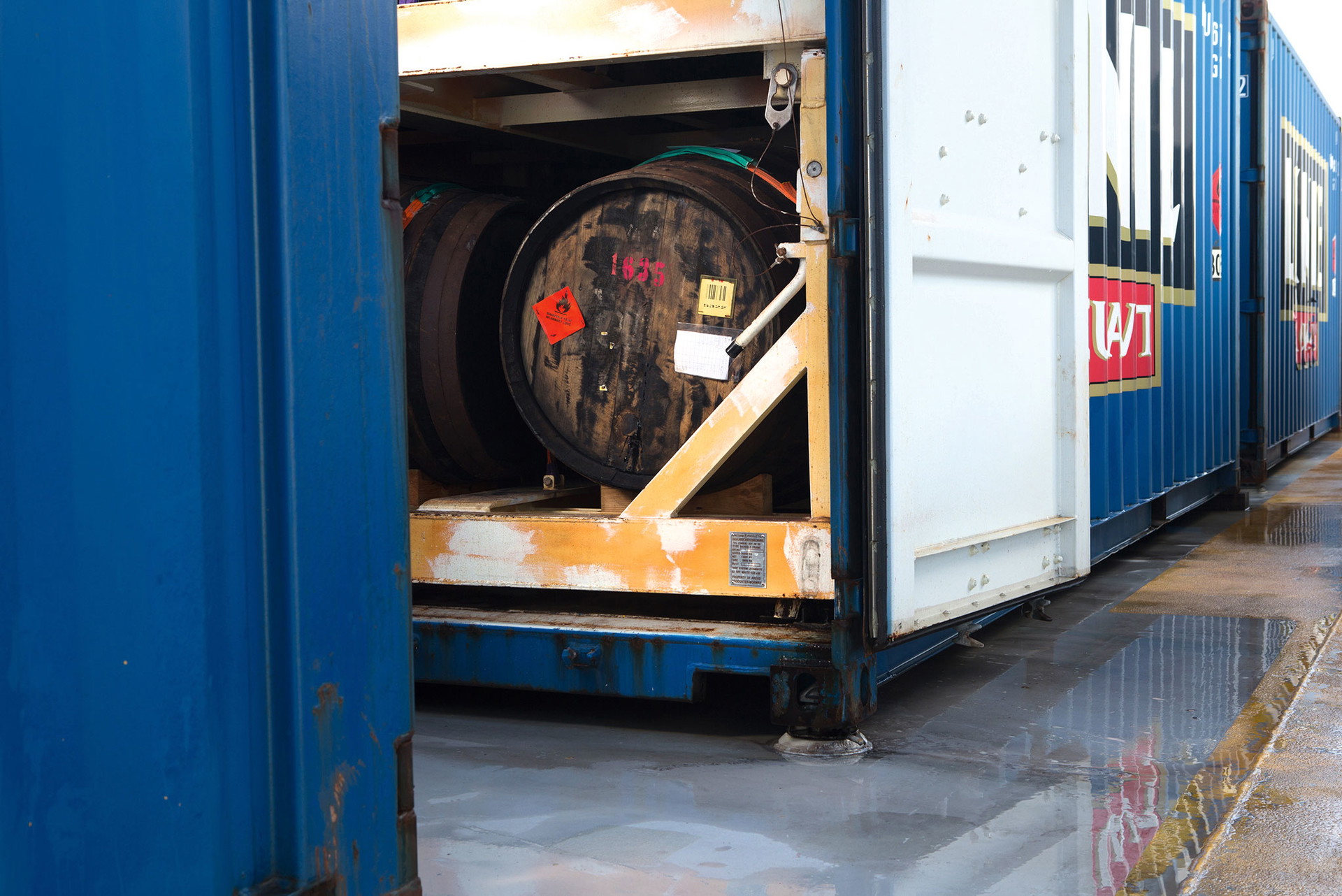 Cask-Cargo: Holz, Metall und Tradition – die ehemaligen Sherry-Fässer voll mit frischem Aquavit warten in den Seecontainern in Hagan auf ihre Äquatortaufe.

