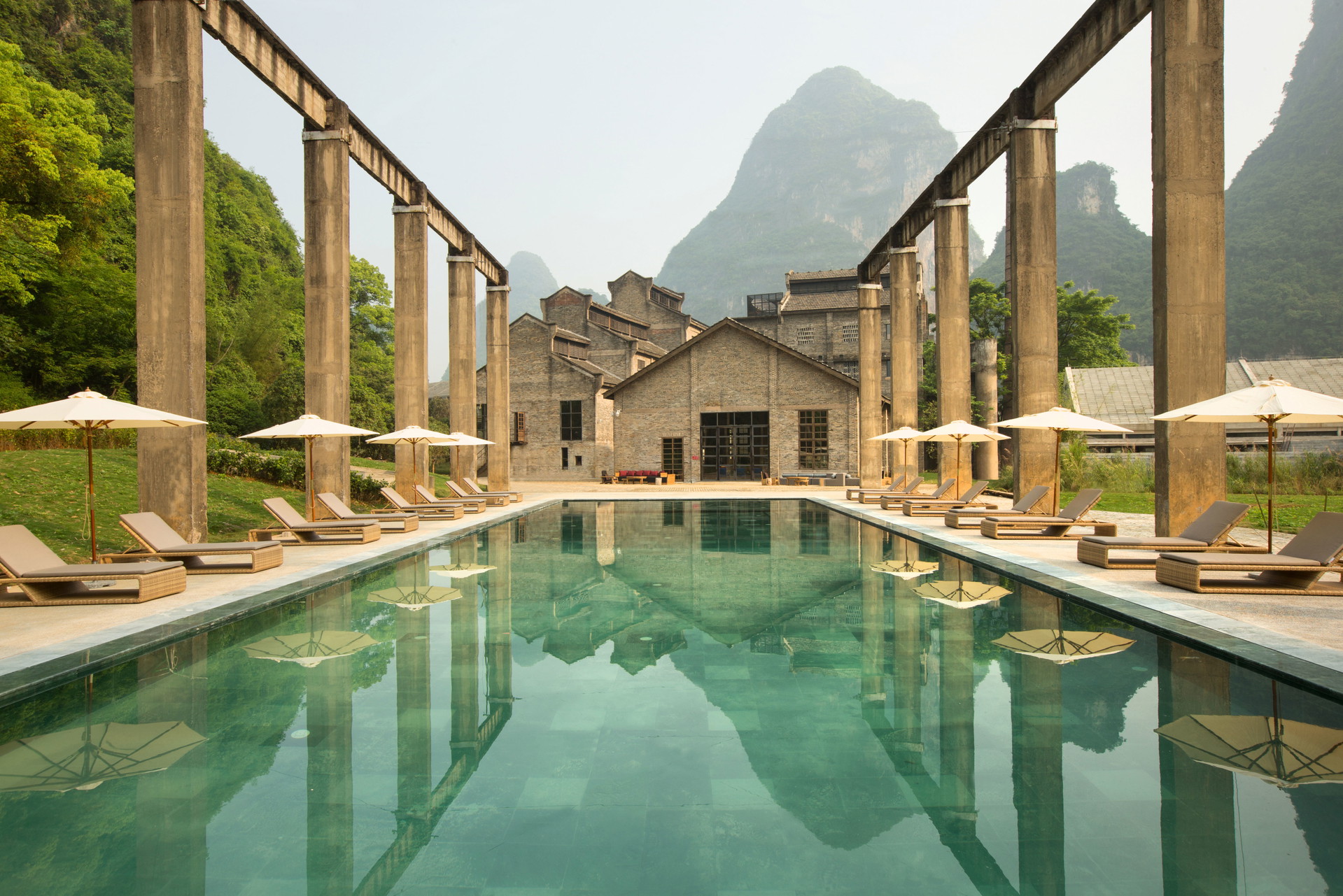 AliLa Hotel, Yangshuo, China: Am Rande von Yangshuo in der Provinz Guangxi wurde diese alte, stillgelegte Zuckerrohrfabrik aus den Sechzigerjahren wachgeküsst. Wo einst die Zuckerrohrhalme verarbeitet und anschließend auf Schiffsdecks geladen wurden, lockt heute das Fünf-Sterne-Luxusresort »Alila« mit insgesamt 117&nbsp;Zimmern. In der Mitte der ehemaligen Krananlage befindet sich ein ver-führerischer Swimmingpool. Gänsehaut pur. alilahotels.com, vectorarchitects.com, cnhorizontal.com