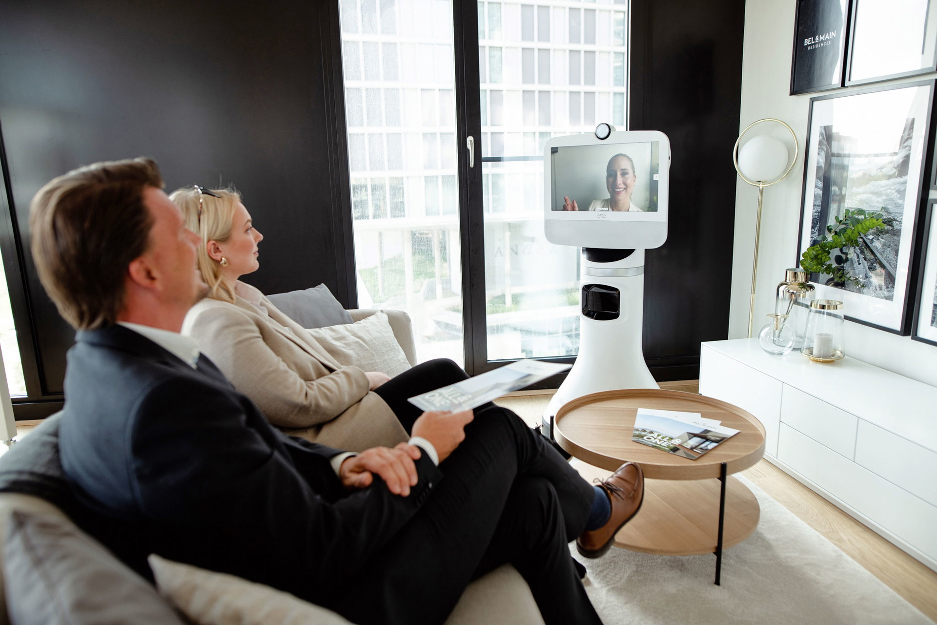 Cyber-Buddy: Der Makler-Roboter AVA passt seine Größe an&nbsp;– sitzen die Immobilieninteressenten, fährt er seinen Kopf nach unten. Sein »Gesicht« zeigt entweder einen echten (anders-wo sitzenden) Menschen oder entsprechende Unter-lagen wie Pläne, Grundrisse, Verträge etc.