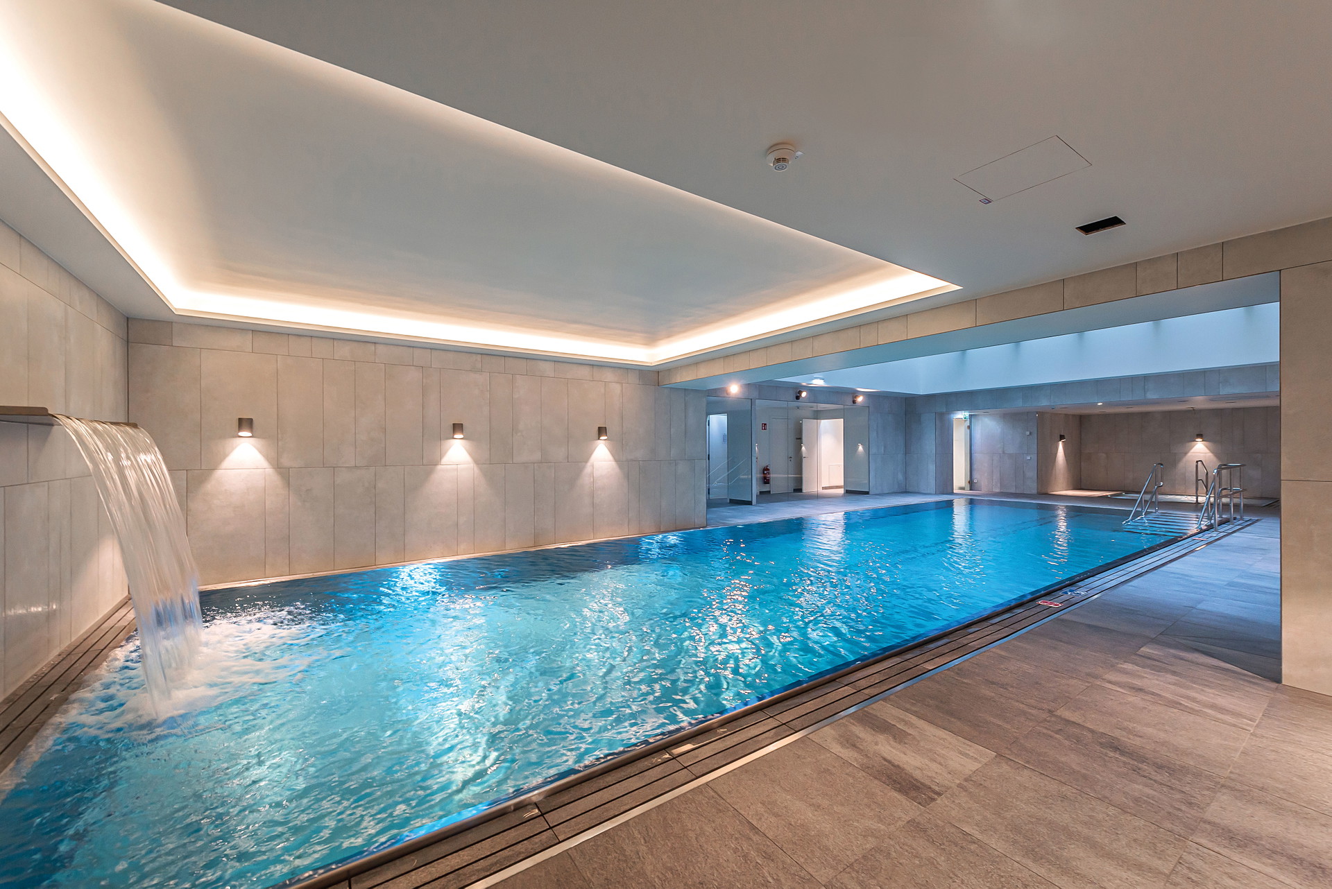 Exklusiver Pool inklusive: Ein 15 Meter langer Pool, Kinderbecken, Saunalandschaft und Fitnessraum – das alles steht exklusiv den Bewohnern des Hauses zur Verfügung.