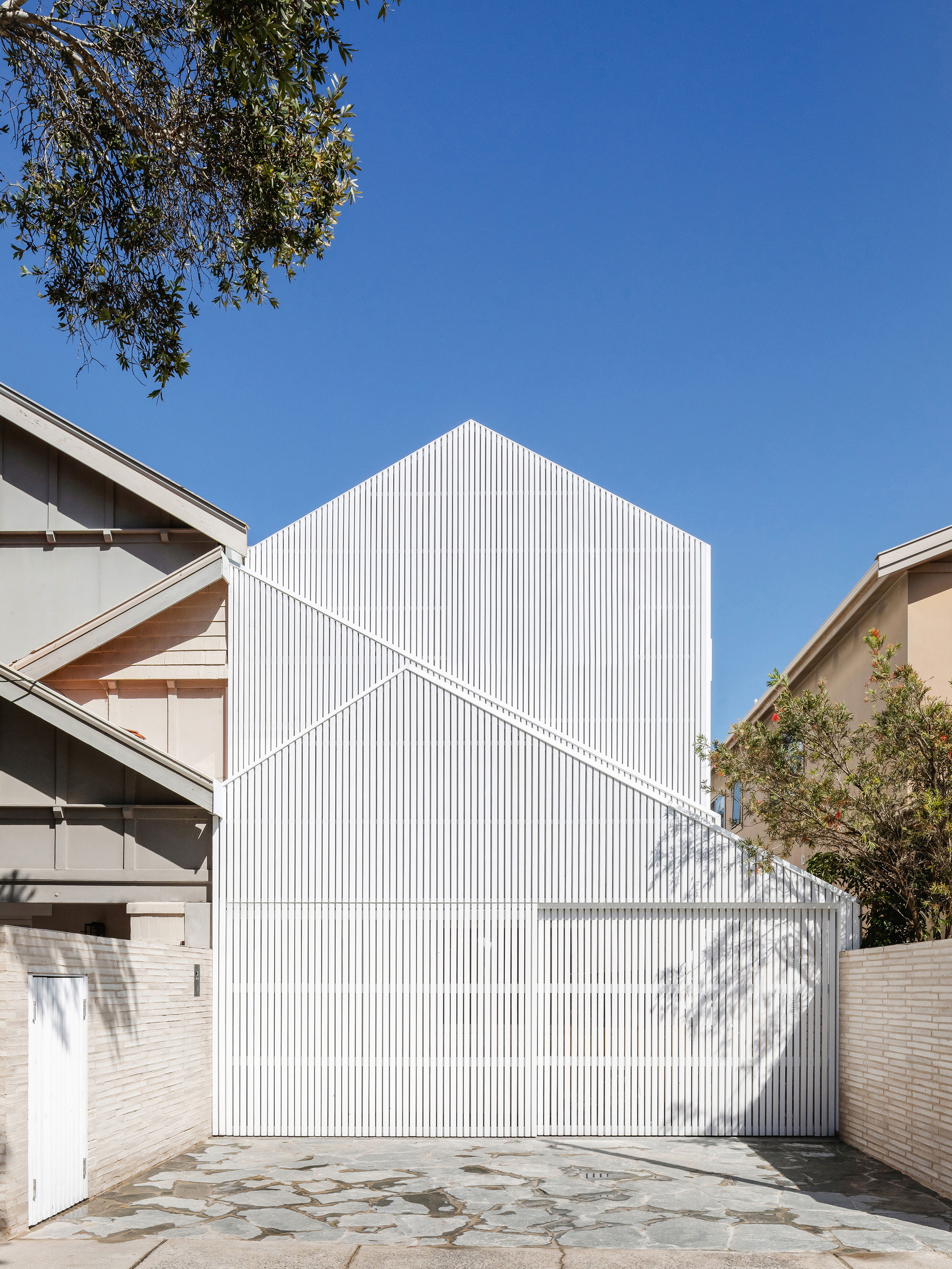Beach-Body: Leicht und sommerlich gibt sich das North Bondi House in Sydney von James Garvan. Hinter der luftigen Hülle aus weißen Holzlatten verbirgt sich ein ebenso weißes Inneres, das Licht und Schatten spielen lässt. jamesgarvan.com