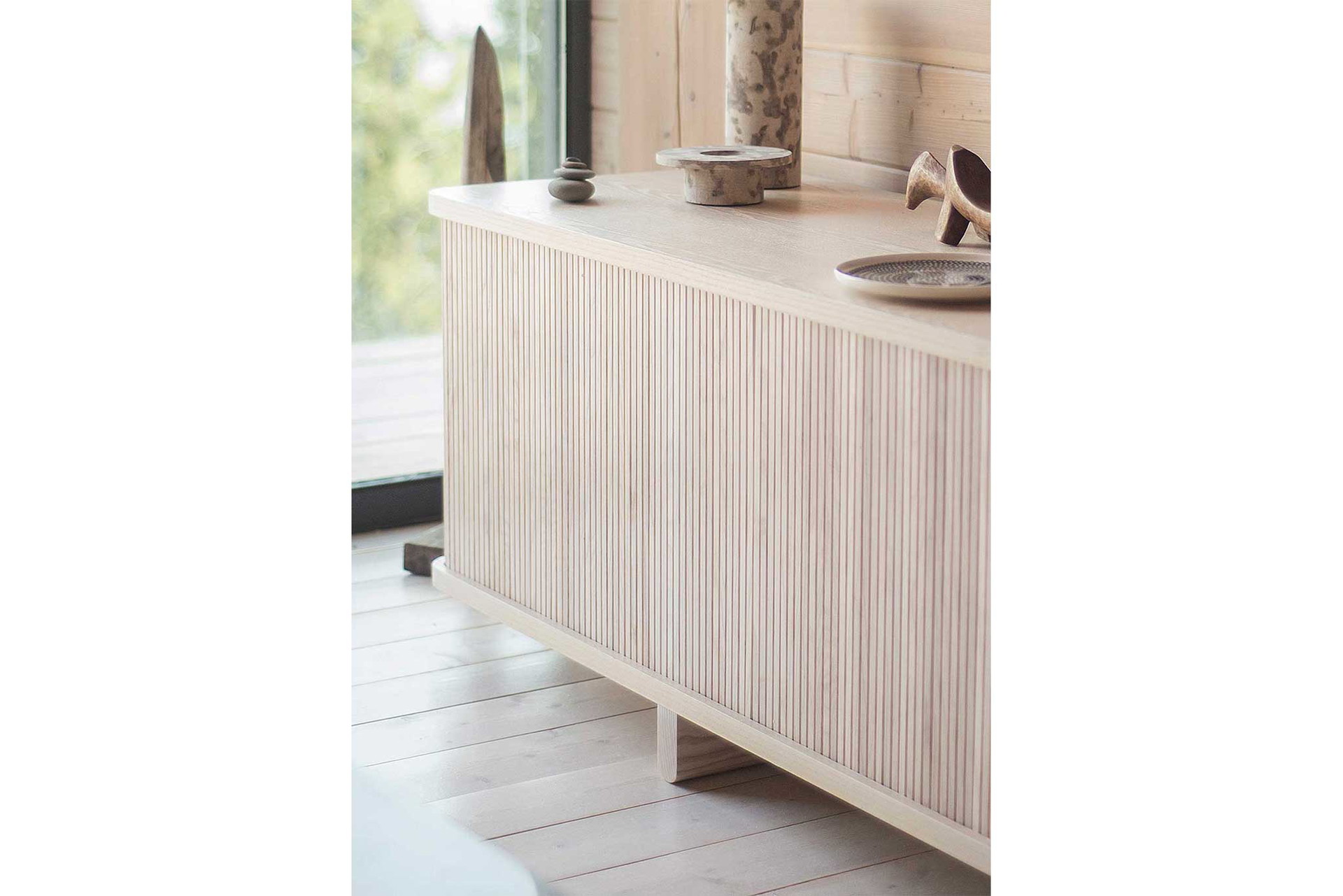 In Anlehnung an&nbsp;traditionelle Rolltische gleiten die&nbsp;flexiblen Holzlatten der »Mjölk Tambour Collection« entlang einer Schiene. Offen gelassen, können Gegenstände so auch optimal präsentiert werden.