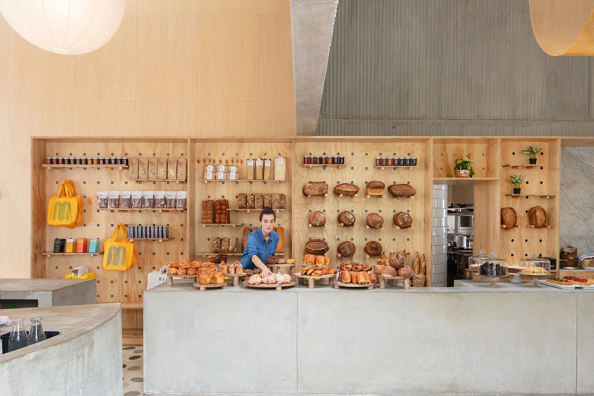 Masa, Bogotá Eine Theke aus Beton, ein Display aus Lochholz und ein gemusterter Terrazzoboden. Hier wirkt das Brot auf der Holzwand kostbar.&nbsp;somosmasa.com