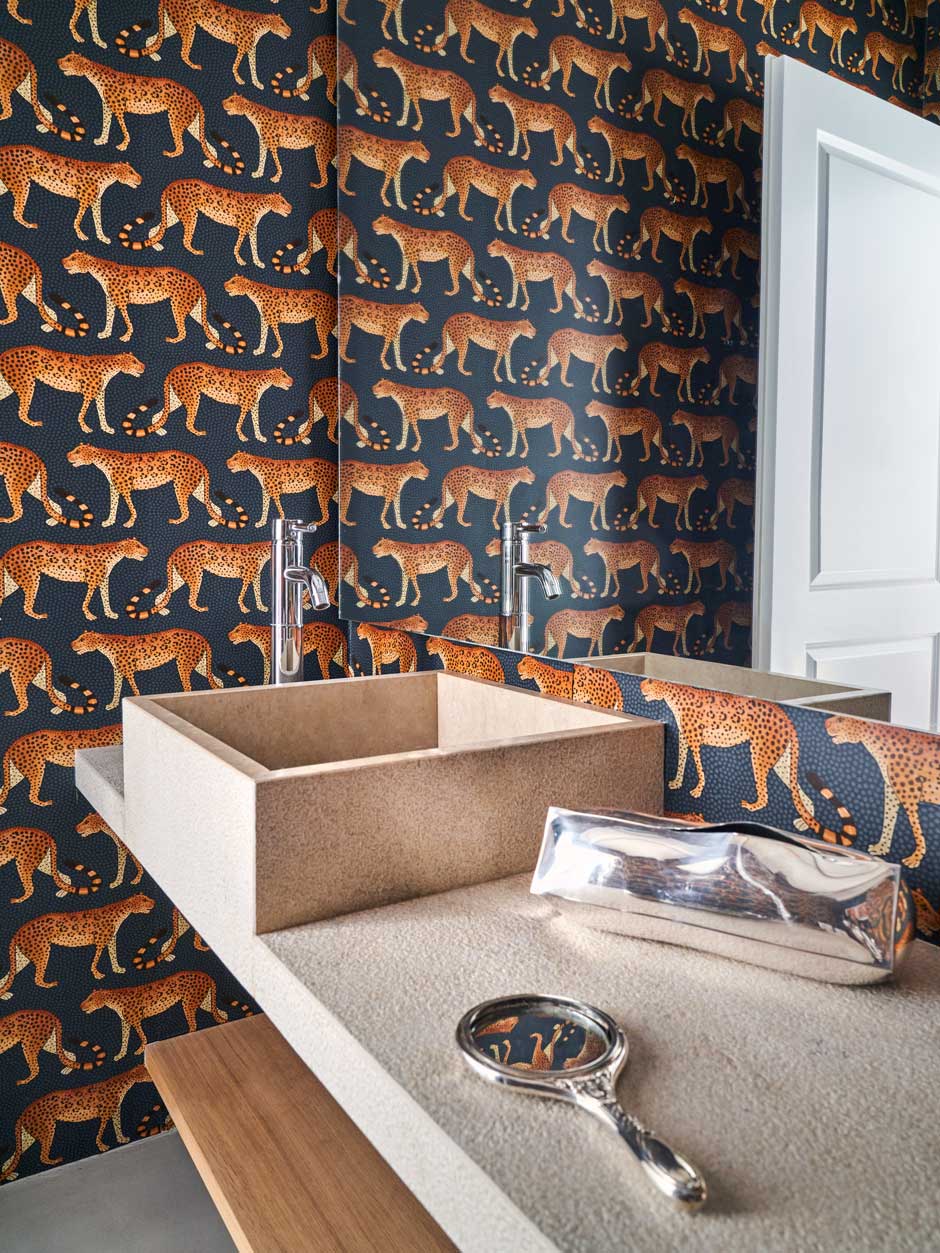 Tierisch&nbsp;Die Tapete mit Raubkatzenmotiv von Cole &amp; Son belebt das Badezimmer samt Waschbecken aus Granit.