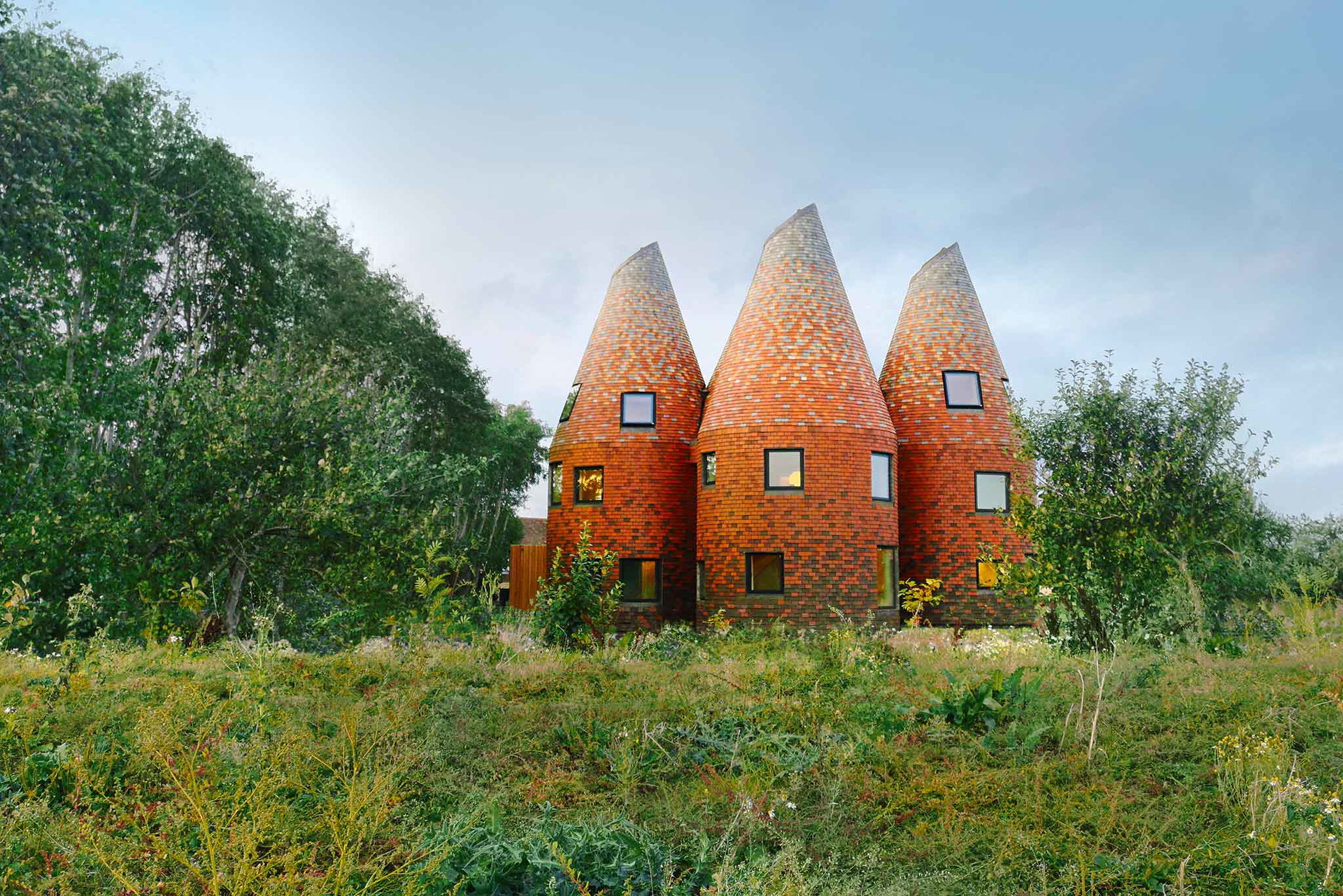Kentish Coast House, Kent, Grossbritannien: Wie ein archaisches Monument steht dieses Wohnhaus auf einer südengli-schen Wiese. Fünf runde Türme mit konischen Köpfen, mit 41.000 Schindeln in sechs Farben verkleidet.&nbsp;acme.ac