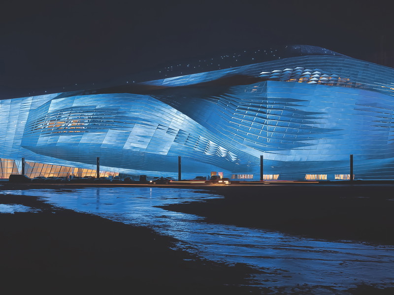 Dalian International Convention Center, China Was immobilientechnisch in den letzten zehn Jahren in China passierte, haben wir in Europa kaum erfasst. Das Convention Center in der bei uns unbekannten Stadt Dalian ist nur ein Beispiel: Das Gebäude würde das Areal der Wiener Staatsoper, Sacher, Bristol und Opernringhof einnehmen. Geplant wurde das 2013 fertiggestellte Kongresszentrum von Coop Himmelb(l)au.