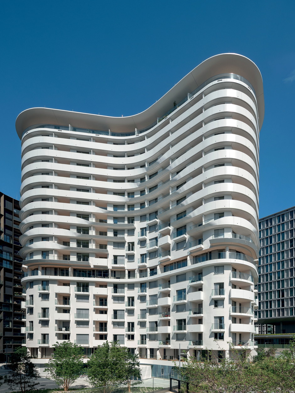 Schöner Anblick&nbsp;Der »BelView Tower« ist ein monolithischer Baukörper von organischer, amöbenähnlicher Grundform. Weiße, pulverbeschichtete Aluminiumpaneele umziehen die gesamte Gebäudekontur und sind in Zonen, gemäß unterschiedlichen Umweltfaktoren wie Wind, Schall und Belichtung, unterbrochen.